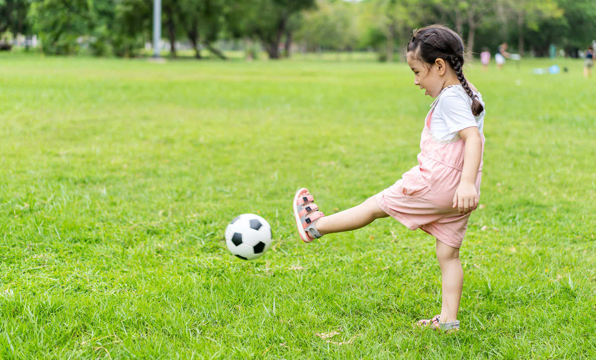 Toddler playing by kicking a ball
