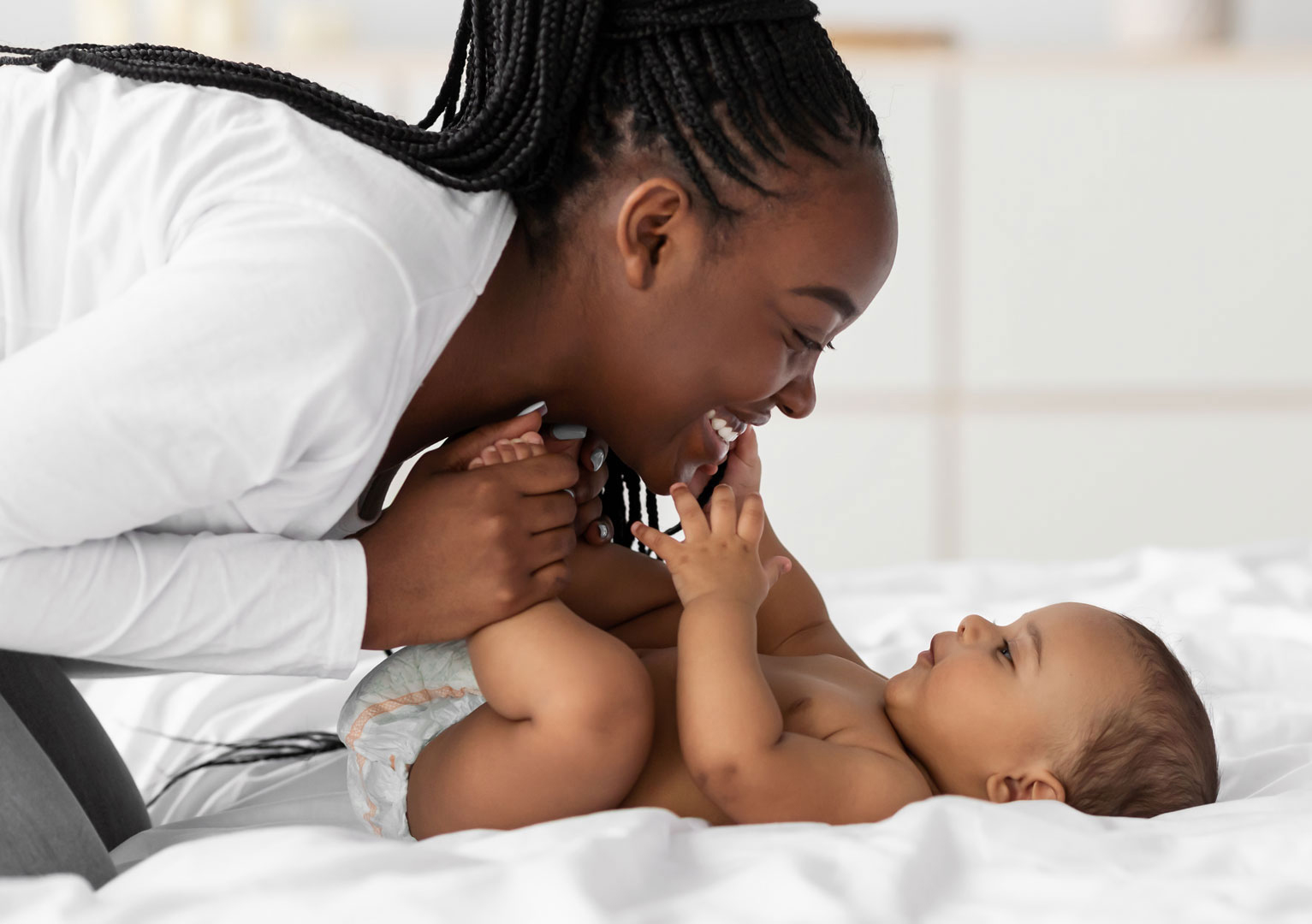 Woman playing with her newborn baby