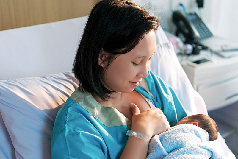 Mom holding and feeding her infant