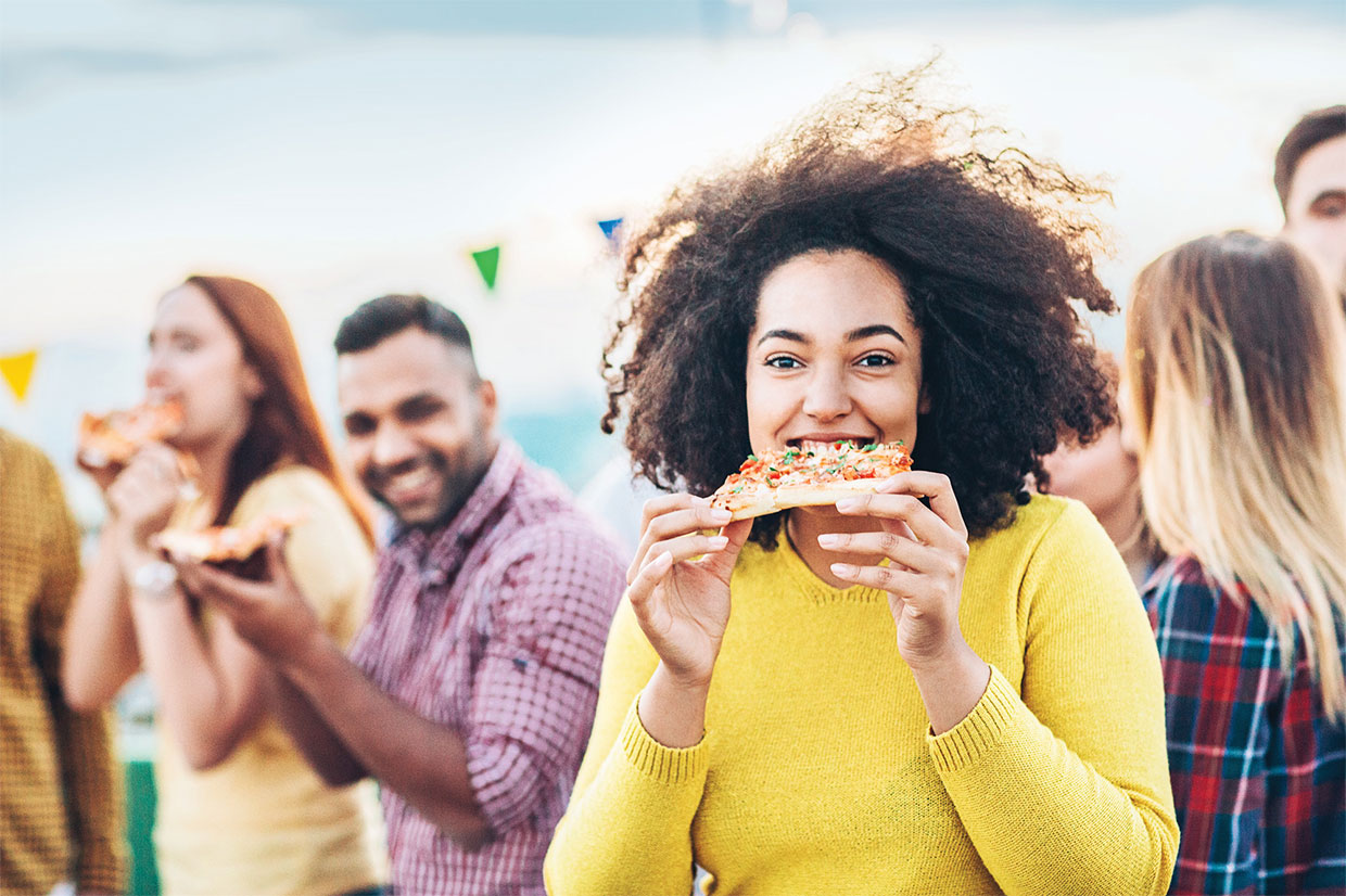 Woman eating a slice of pizza